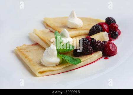 Sur des crêpes fines avec du fromage à la crème et des baies. Banque D'Images