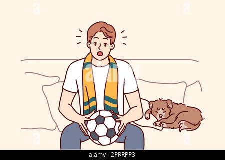 Un jeune homme s'assoit sur un canapé pour regarder un match de football à la maison. Fan de sport masculin avec balle dans les mains, profitez d'un match à l'intérieur. Illustration vectorielle. Banque D'Images
