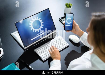 Femme effectuant une mise à jour de logiciel sur un téléphone mobile Banque D'Images