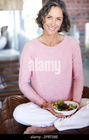 Profiter d'une longue vie grâce à une vie saine. Portrait d'une femme mature mangeant une salade Banque D'Images