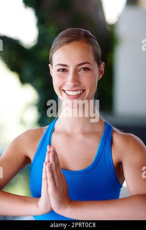 Le yoga est tout ce dont j'ai besoin. Une jeune femme qui profite d'un cours de yoga relaxant Banque D'Images