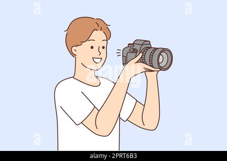 Jeune homme souriant avec un appareil photo professionnel qui prend des photos. Joyeux photographe travaillant avec l'équipement. Photographie. Illustration vectorielle. Banque D'Images