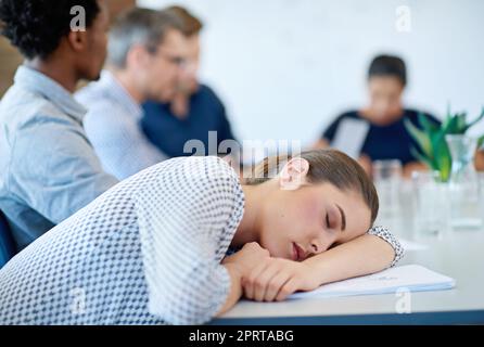 Besoin de plus d'énergie pour maintenir votre avantage. Jeune femme endormi sur une table de conférence pendant une réunion d'affaires Banque D'Images