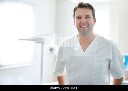 Votre dentiste amical. Portrait d'un dentiste debout près de l'équipement dentaire dans son bureau Banque D'Images