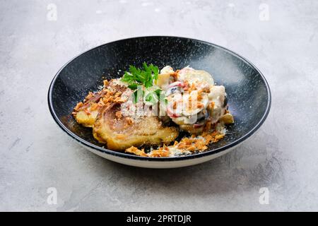 Concombre mariné à la pomme de terre bouillie et aux olives servi avec des tranches de poitrine de porc frites Banque D'Images