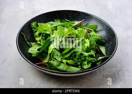 Assiette avec assortiment de feuilles de salade fraîches Banque D'Images