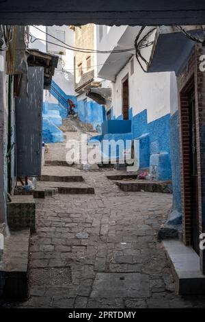 Ruelle raide et étroite de la médina de Tétouan avec les maisons peintes en blanc et bleu. Banque D'Images