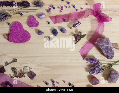 Bijoux violet et rose avec coeurs à paillettes et pierres améthystes sur fond en bois Banque D'Images