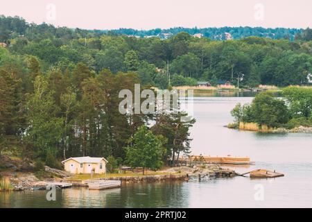 Suède.Magnifiques chalets en bois suédois Maisons sur la côte des îles Rocheuses en été.Paysage de lac ou de rivière. Banque D'Images