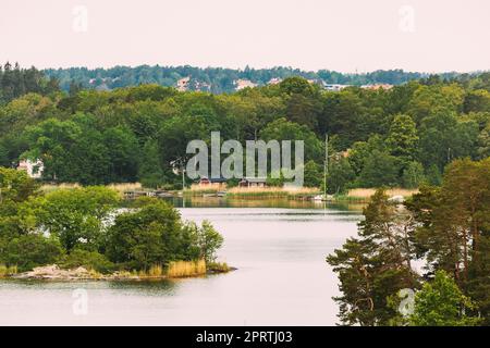 Suède. Belles chalets en bois suédois Maisons sur la côte en été. Paysage de lac ou de rivière. Banque D'Images