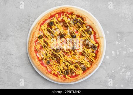 Vue de dessus de pizza de petite taille avec viande de bœuf hachée, maïs doux et moutarde Banque D'Images