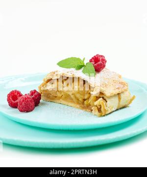 Tranche de strudel de pomme sur une plaque ronde, fond blanc Banque D'Images