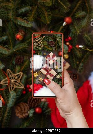 Mains de femmes prenant une photo mobile de composition de noël vue du dessus Banque D'Images