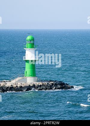 Phare blanc vert sur la rivière Warnow à Rostock. Vagues sur le bord de la pierre Banque D'Images