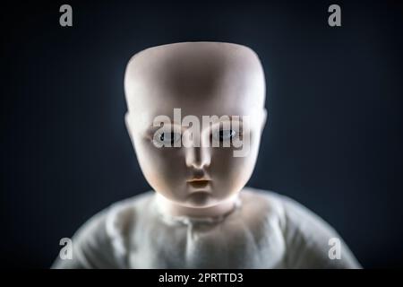 Visage de poupée créepy sur fond sombre Banque D'Images