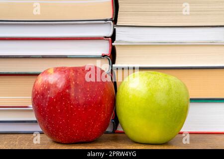Pommes rouges et vertes avec des livres empilés sur le fond Banque D'Images