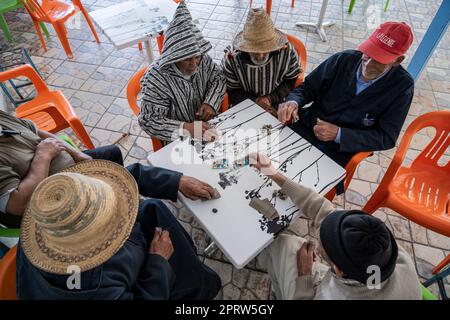 Groupe d'hommes jouant aux cartes sur la terrasse d'un bar à Oued Laou. Banque D'Images