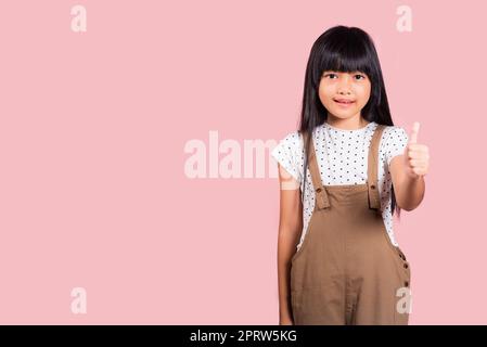 Petit enfant asiatique de 10 ans qui se montre à la hauteur Banque D'Images