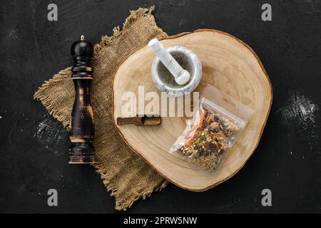 Section transversale en bois avec kit pour les épices à vin moulues dans un emballage en plastique, mortier et moulin Banque D'Images