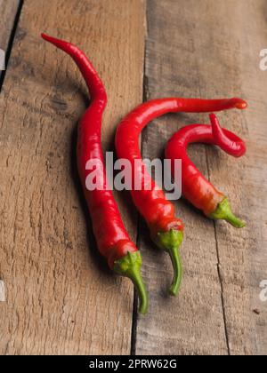 Trois délicieux piments rouges biologiques sur bois Banque D'Images