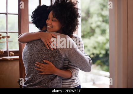 Vous êtes enfin à la maison. Une jeune femme salue son mari à la porte. Banque D'Images