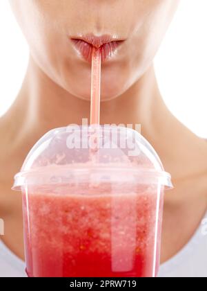 Ce smoothie est bon pour les baies. Photo studio d'une belle jeune femme en dégustant un smoothie aux fruits Banque D'Images