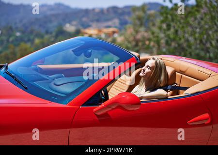 Symbole de succès... une jeune femme volant dans une voiture de sport Banque D'Images