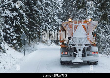 Entretien roué en hiver, camion nettoyant la neige de la route Banque D'Images