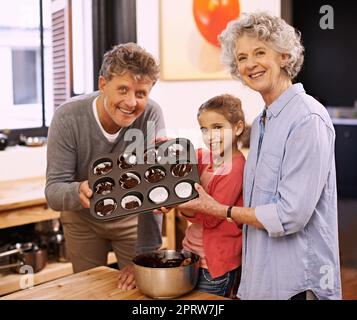 Regardez ce que vous avez fait. Une petite fille qui cuisine avec ses grands-parents Banque D'Images