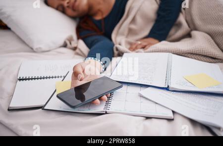 Le téléphone, les livres et la femme dormanteuse étudiante fatiguée de l'apprentissage, l'étude et l'éducation papier d'examen au lit. Une jeune fille d'université ou d'université se repose avec un smartphone mobile pour les documents de recherche en ligne Banque D'Images