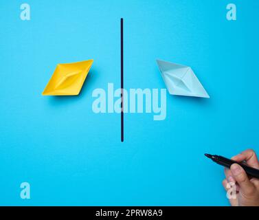 Deux bateaux en papier et une ligne tracée avec un marqueur entre eux. Concept de réconciliation, arrêter le conflit Banque D'Images
