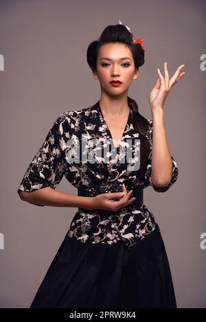 Je suis fier de ma culture. Photo en studio d'une jeune femme attirante vêtue de vêtements asiatiques traditionnels Banque D'Images