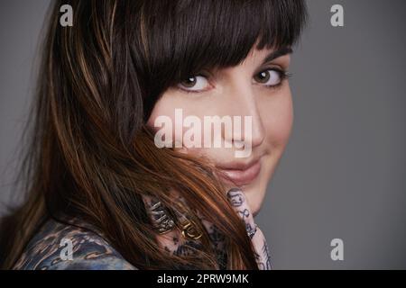 Je définit ma beauté. Un petit portrait de studio d'une belle jeune femme tatouée Banque D'Images