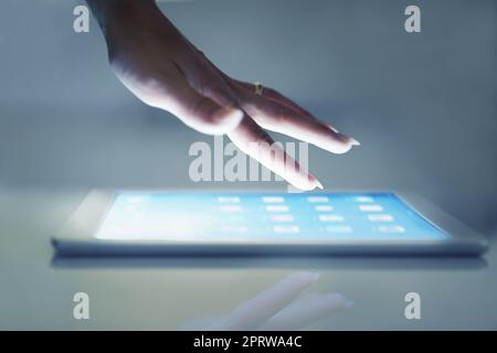 Technologie intuitive. Gros plan court d'une main de femme au-dessus d'une tablette numérique. Banque D'Images