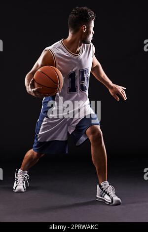 Prendre tous les comers. Photo studio d'un joueur de basket-ball sur fond noir Banque D'Images