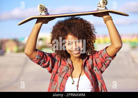 Skateboardings le vrai gagnant. Une jeune femme avec son skateboard dans un skatepark Banque D'Images