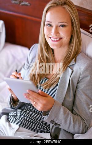 Il est temps de prendre la parole avec mon plus proche et le plus cher. Une jeune femme d'affaires utilisant une tablette numérique dans une chambre Banque D'Images