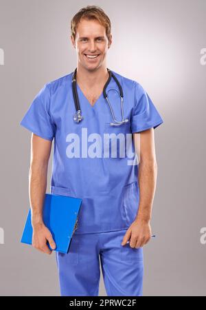 HES heureux d'être la guérison. Un portrait en studio d'un beau médecin souriant tenant une planchette à pince. Banque D'Images