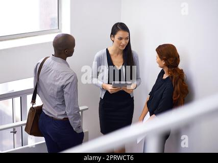 Je me demande pourquoi j'ai appelé cette réunion ici. Des collègues se rassemblent dans un escalier. Banque D'Images