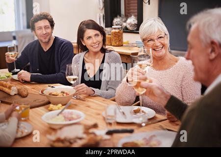 Des encouragements à la famille. Une famille s'assoit pour dîner Banque D'Images