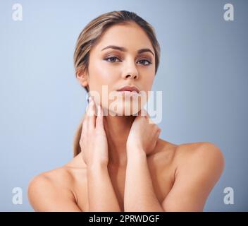 Shes une beauté naturelle. Photo studio d'une belle jeune femme sur fond bleu Banque D'Images