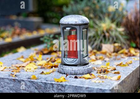 lanterne contemporaine sur une tombe en marbre avec des feuilles d'automne Banque D'Images