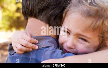 Daddys toujours là. Une petite fille malheureuse étant réconfortée par son père. Banque D'Images