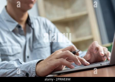Gros plan homme travaillant et tapant sur ordinateur portable clavier travail à domicile, télétravail, concept d'apprentissage en ligne. Banque D'Images