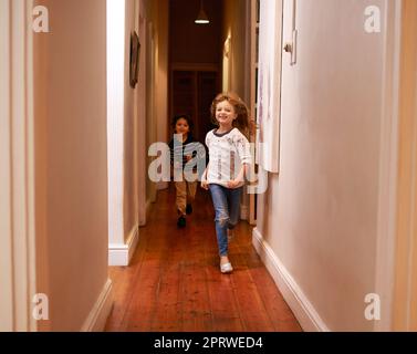 N'allez pas dans la maison. Deux enfants s'couraient dans un couloir. Banque D'Images