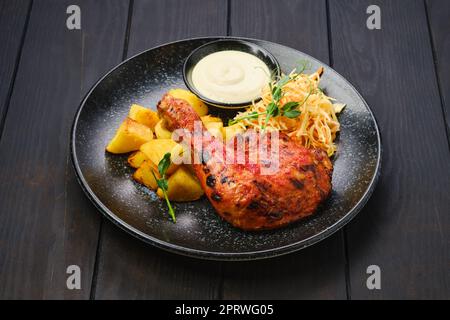 Cuisse de poulet rôtie avec quartiers de pommes de terre et chou mariné Banque D'Images