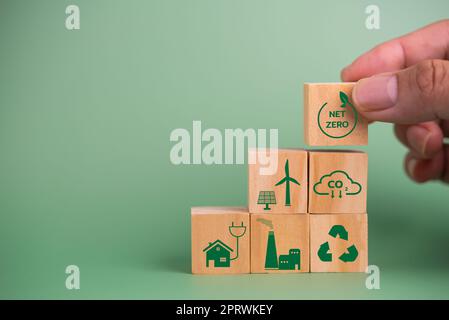 icône de bloc de cube en bois zéro crédit de carbone net et écoénergie technologie verte sur fond vert. Banque D'Images