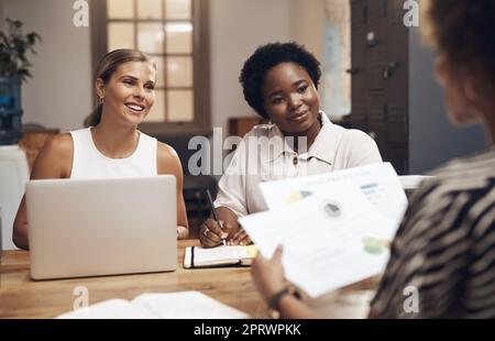 L'équipe pour tourner autour d'une entreprise. Un groupe de jeunes femmes d'affaires ayant une réunion dans un bureau moderne. Banque D'Images