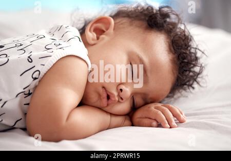 Doux rêves, doux un adorable bébé garçon dormant paisiblement sur le lit à la maison. Banque D'Images