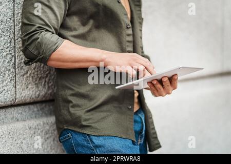 Restez connecté grâce à la technologie sans fil. Un homme d'affaires utilisant une tablette numérique dans un environnement urbain. Banque D'Images